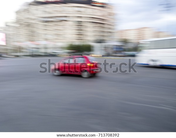 Unfocused city scene with car speeding through\
the streets of Bucharest,\
Romania.