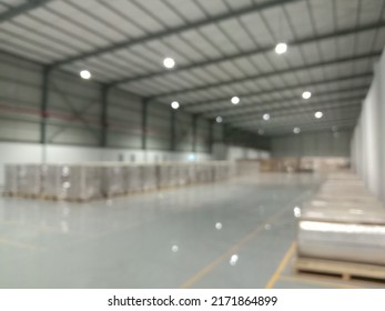 An Unfocused Image Of An Empty, Brightly Lit Room In An Industrial Factory. Creative Blurred Background Template.