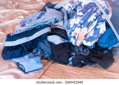 unfolded clothes on bed 