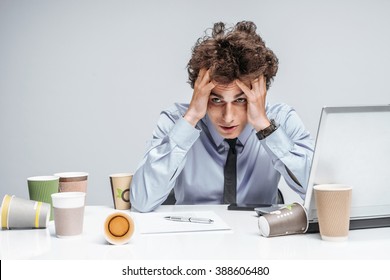 Unfortunate manager dissatisfied with his work. Modern businessman at the workplace working with computer, depression and crisis concept