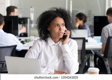 Unhappy African American Woman Talking On Phone With Client Or Customer, Consulting, Receiving Bad News, Having Unpleasant Conversation At Workplace, Problem With Complaining, Looking In Distance