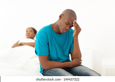 unhappy african man having a fight with wife in bedroom
