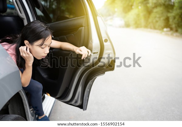 Unhappy asian child girl about to throw up from\
car sick or indigestion,female teenage vomiting in a car suffers\
from motion sickness or food poisoning,sad woman feel dizzy and\
nauseous from carsick