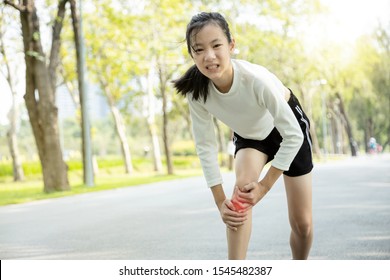 Unhappy Asian Child Girl Injured Her Leg Pain Or Calf Muscle While Playing In Sunny Day, Female Teenage Holding Hands On The Legs,feel Pain In The Knee From Exercise In Summer,physical Injury Concept