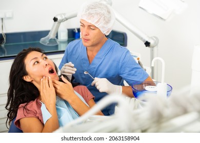 Unhappy asian patient woman having a toothache in dental chair at modern dental clinic