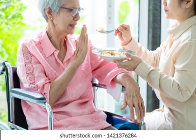 Unhappy Asian Senior Woman Rejecting,gesture Hand “NO” Elderly Patient Bored With Food Or Boredom,old People Getting Sick And Tired Of Food In Wheelchair At Home,loss Of Appetite,anorexia Concept