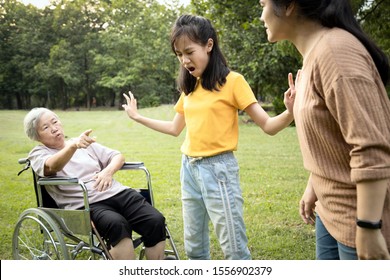 Unhappy Asian Teen Granddaughter Dissuade Her Family From A Fight Something Money,angry Senior Mother And Daughter Arguing Violently,shouting Quarreling At Park, Borrowing Money And Not Returning It