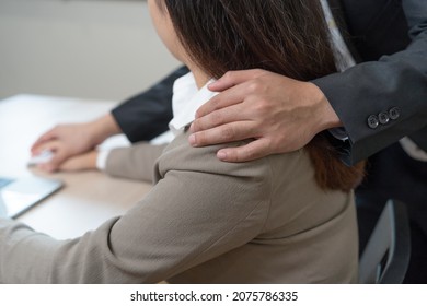 Unhappy asian young woman employee, man employer, colleague or boss touching at her shoulder feeling disgusted, uncomfortable. Sexual harassment inappropriate of business people at office, workplace.