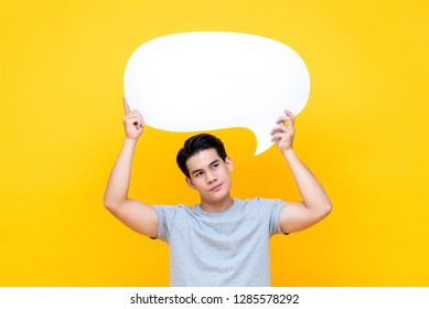 Unhappy Bored Young Asian Man With Empty Speech Bubble On Colorful Yellow Background