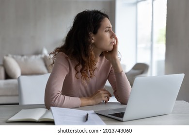 Unhappy Bored Young Hispanic Woman Sit At Desk At Home Office Feel Unmotivated Working On Laptop Online. Upset Bothered Millennial Latino Female Student Lack Motivation Studying. Boredom Concept.