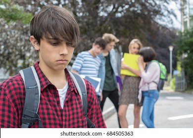 Unhappy Boy Being Gossiped About By School Friends - Powered by Shutterstock