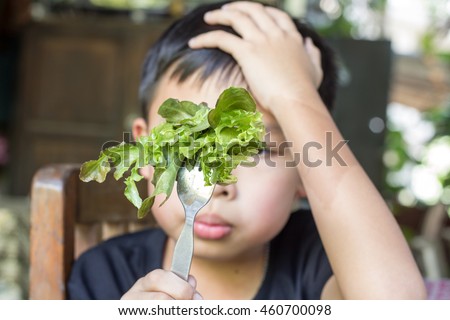 Unhappy boy does not want to eat healthy vegetables , refusing ,boring and ignored it. 