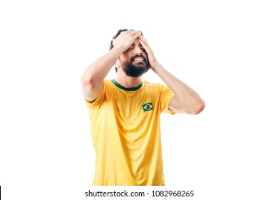 Unhappy Brazilian soccer or football player with palm on his face on white background