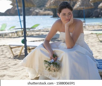 An Unhappy Bride Sitting On A Beach