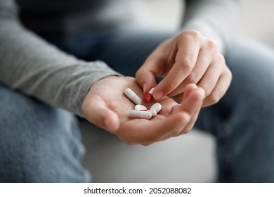 Unhappy caucasian millennial woman suffering from depression holds pills on her hand, close up, cropped, empty space. Disease treatment, painkillers and antidepressants, mental problems, treatment