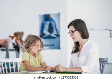 Unhappy Child Refusing To Do Exercises From A Book With A School Counselor