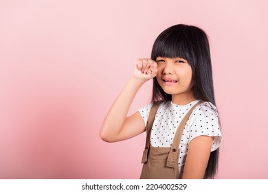 Unhappy Children. Asian Little Kid 10 Years Old Bad Mood Her Cry Wipe Tears With Fingers At Studio Shot Isolated On Pink Background, Child Girl Stress Feeling Sad Unhappy Crying