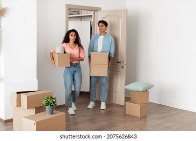 Unhappy Confused Millennial Couple Homeowners Holding Cardboard Boxes Walking In New House, Young Family Of Two People Moving Into Bad Flat, Sad Guy And Lady Disappointed In Interior Design