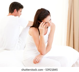 Unhappy Couple Having An Argument Sitting On Their Bed