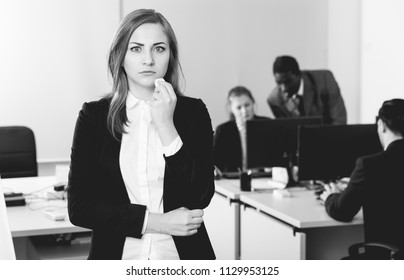 Unhappy and crying girl standing at modern open plan office on background with coworkers - Shutterstock ID 1129953125