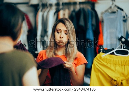 
Unhappy Customer Checking the Quality of a Textile Material. Woman checking the garment before buying a clothing item
