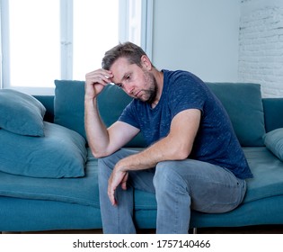 Hombre caucásico infeliz y deprimido llorando en el sofá de la sala de estar sintiéndose desesperado y solitario aislado en casa. En estrés por trabajo, desempleo, ansiedad, desconsolación y concepto de depresión