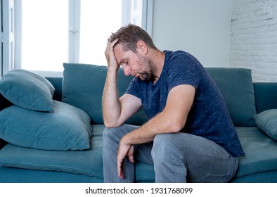 Unhappy depressed caucasian male crying in living room couch feeling desperate and lonely isolated at home. In stressed from work, unemployment, anxiety, heartbroken and depression concept - Shutterstock ID 1931768099