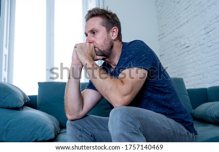 Unhappy depressed caucasian male crying in living room couch feeling desperate and lonely isolated at home. In stressed from work, unemployment, anxiety, heartbroken and depression concept