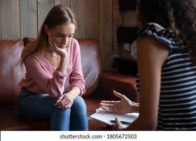 Unhappy depressed young woman listening to psychologist at meeting, African American woman therapist counselor consulting stressed frustrated girl at counselling therapy session, explaining diagnosis