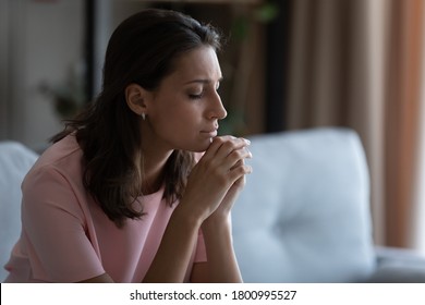 Unhappy distressed young Arabic indian woman sit on sofa at home thinking pondering, upset depressed arab mixed race female mourn yearn in living room, feel stressed with abortion miscarriage problems - Shutterstock ID 1800995527
