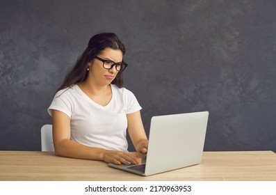 Unhappy Distressed Young Latin Woman In Glasses Sit At Table Work On Computer Frustrated By Bad Negative News. Mad Depressed Millennial Hispanic Female Confused Stressed With Laptop Problem.