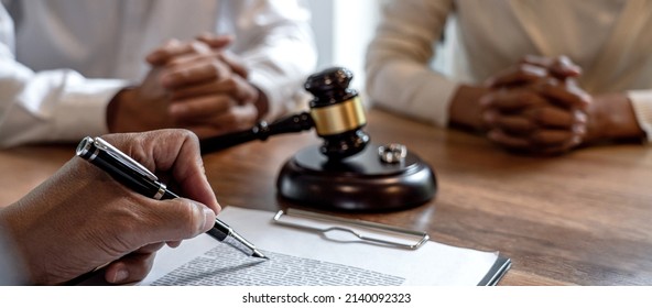 Unhappy divorce couple having conflict, husband and wife during divorce process with senior male lawyer or counselor and couple signing decree of divorce contract in lawyer's office. - Shutterstock ID 2140092323