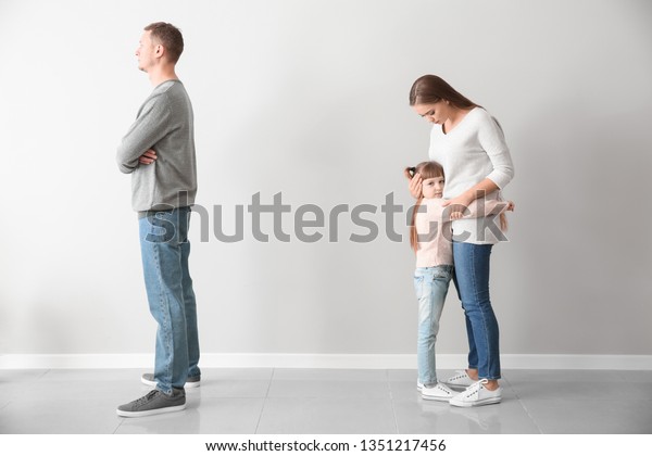 Unhappy family\
after quarrel against light\
wall