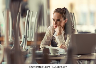 Unhappy Female Pub Owner Sits Over Computer And Coffee Thinking About What To Do As Business Are Forced To Remain Closed Due To Pandemic.