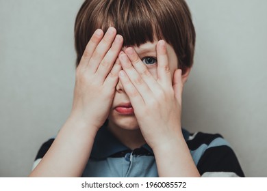 Unhappy kid boy hands hides his face, child mental health concept, world autism awareness day, teen autism spectrum disorder awareness concept - Shutterstock ID 1960085572