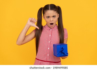 Unhappy Kid Hold Gift Box On Yellow Background Show Thumb Down, Dislike