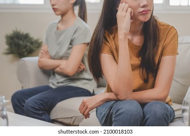 Unhappy lesbian, lgbt asian young two women, girl gay, couple love fight on sofa, relationship is in trouble. Different people are angry and use emotions at each other, expression of disappointmen. - Shutterstock ID 2100018103