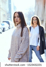 Unhappy LGBT Lesbian Couple In The Street Of The City. Dissapointed Beautiful Brunette Woman In Quarrel With Her Girlfriend. Couple Having Problems In Relationship.