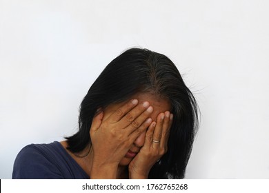 Unhappy Lonely Depressed Asian Woman Covers Her Face. Concept Of Unemployment, Sadness, Depression, Mid Life Crisis.  White Background.