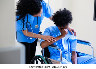 Unhappy Lonely Depressed And Sad Feeling. Black Man Patient Siting On Wheelchair With Black Woman Nurse At Medical Center.