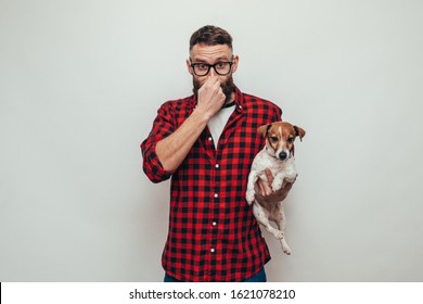 Unhappy Male With Beard Holding His Dirty Dog. Bad Smell Pet Needs To Be Washed.