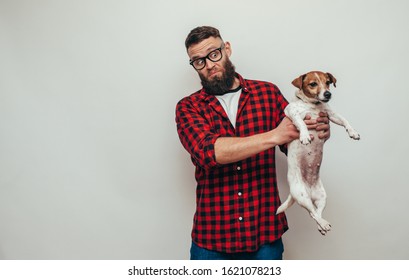 Unhappy Male With Beard Holding His Dirty Dog. Bad Smell Pet Needs To Be Washed.