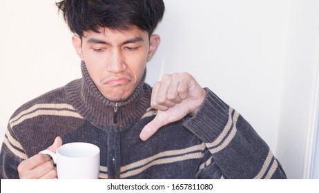 Unhappy Man With Coffee Cup On Hands It's Very Bad Taste.                          