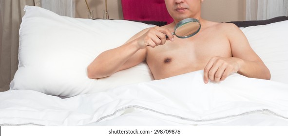 Unhappy Man With Sex Problem On Bed. Concept = Too Small To See Without Magnifier