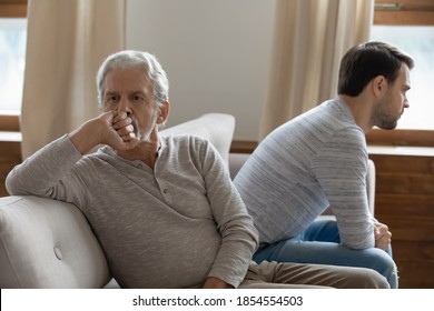 Unhappy Mature Father And Adult Son Not Taking After Quarrel, Sitting On Couch At Home Separately Back To Back, Upset Older Grandfather And Grandson Ignoring Each Other, Two Generations Conflict