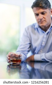 Unhappy Mature Man With Alchol Problem Holding Glass Of Whiskey At Home