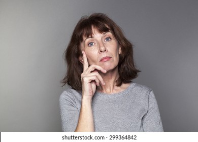 Unhappy Mature Woman With Brown Hair And Grey Sweater Thinking,looking Annoyed And Concerned