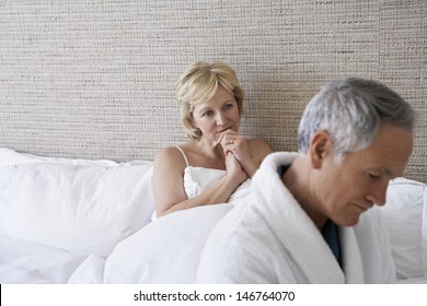 Unhappy Middle Aged Couple In Bedroom