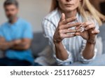 Unhappy middle aged european lady takes off ring, ignoring man during quarrel in living room interior, cropped. Relationship problems, divorce, scandal and breakup, emotions at home due covid-19