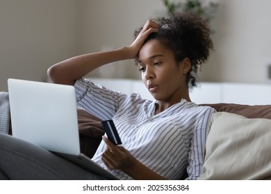 Unhappy millennial African American woman distressed with problems paying online on laptop with credit debit card. Upset young ethnic female confused have troubles shopping on web on computer. - Shutterstock ID 2025356384